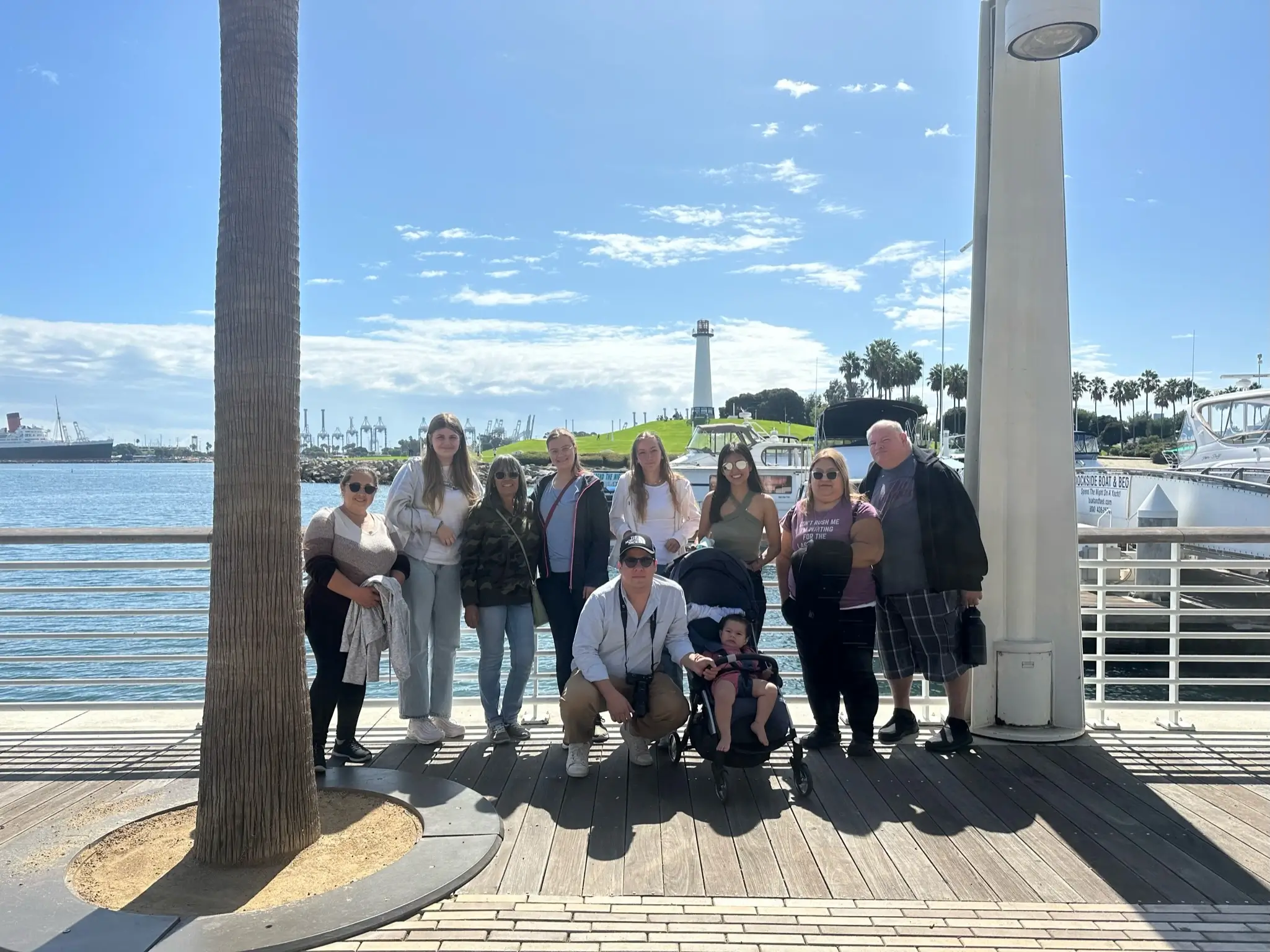 International participants and host family members gather at a waterfront promenade during a shared community outing in the United States.