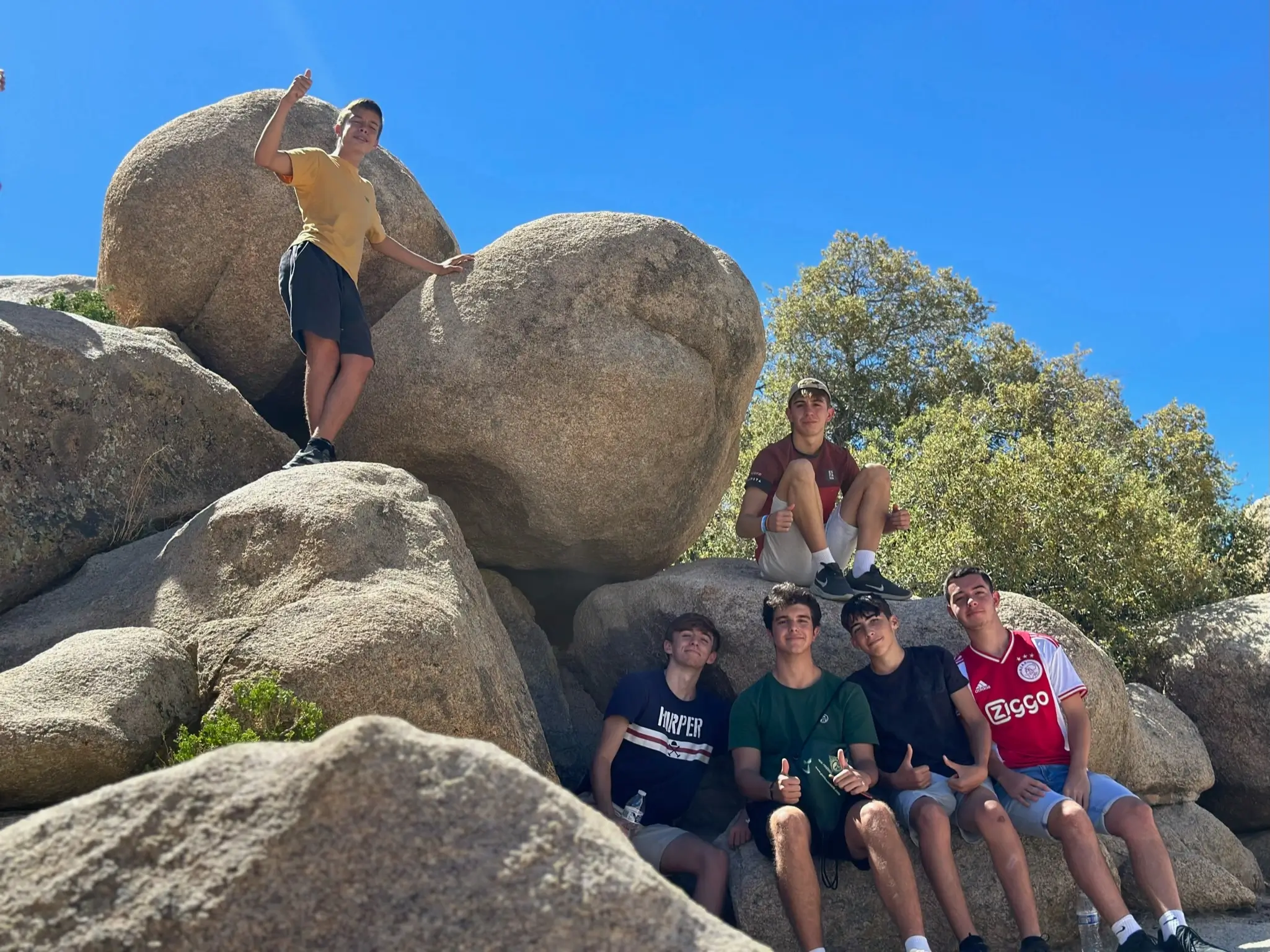 International students climb large rocks during an ERDT enVision outdoor adventure in California