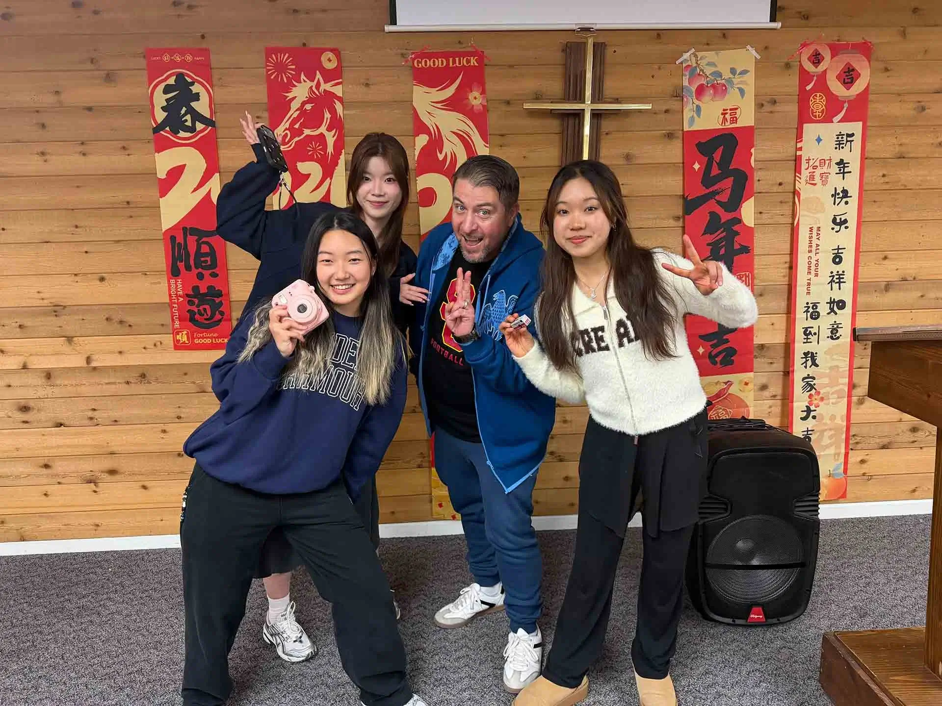 YCE University Program students celebrate Lunar New Year with a host and festive decorations indoors