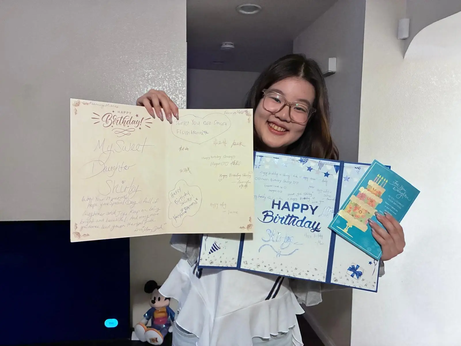 YCE University Program student smiling while holding birthday cards and gifts during a homestay birthday celebration